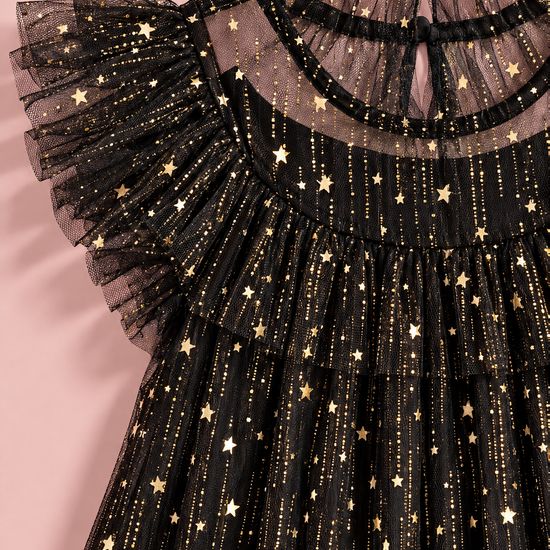 Close up of the gold foil stars and glitter on the black tulle, the ruffle collar and the flutter sleeve