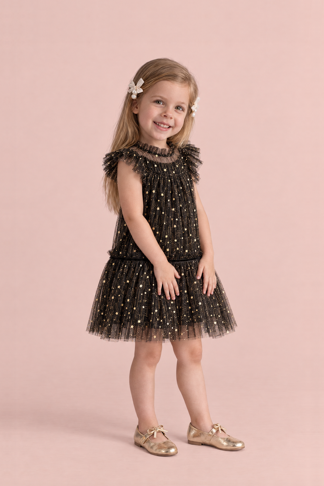 Stardust Black Star Tulle Party Dress, three quarter view, smoothing her skirt with both hands, showing the ruffle collar and drop waist skirt