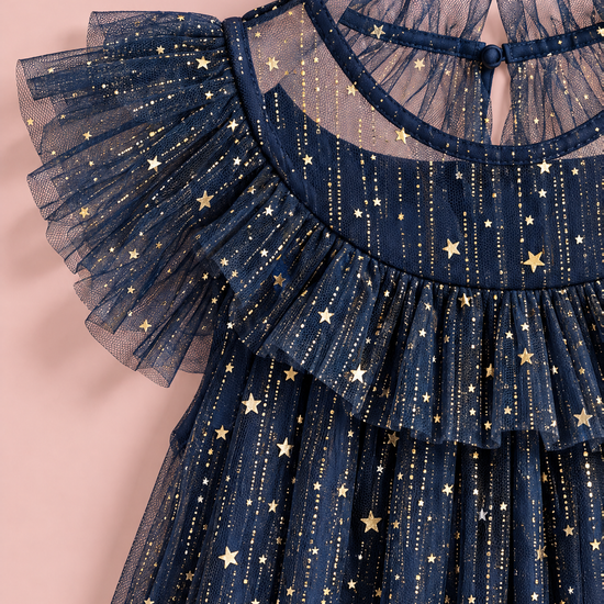 Close up of the gold foil stars and glitter on the navy tulle, the ruffle collar and the flutter sleeve