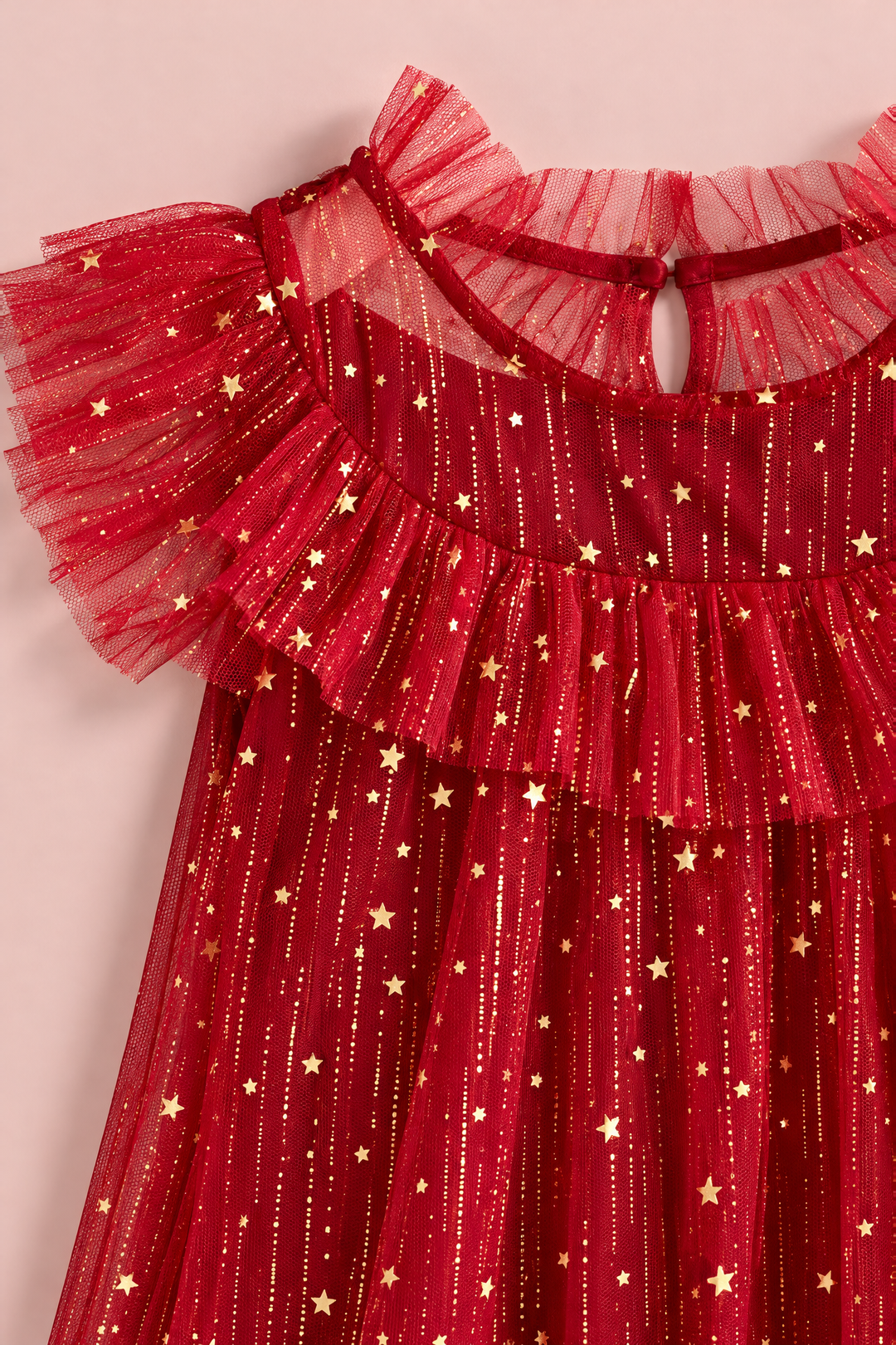 Close up of the gold foil stars and glitter on the red tulle, the ruffle collar and the flutter sleeve