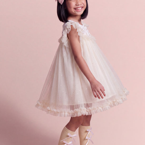Three quarter view of the Primrose ivory flower girl dress showing the depth of the tulle skirt
