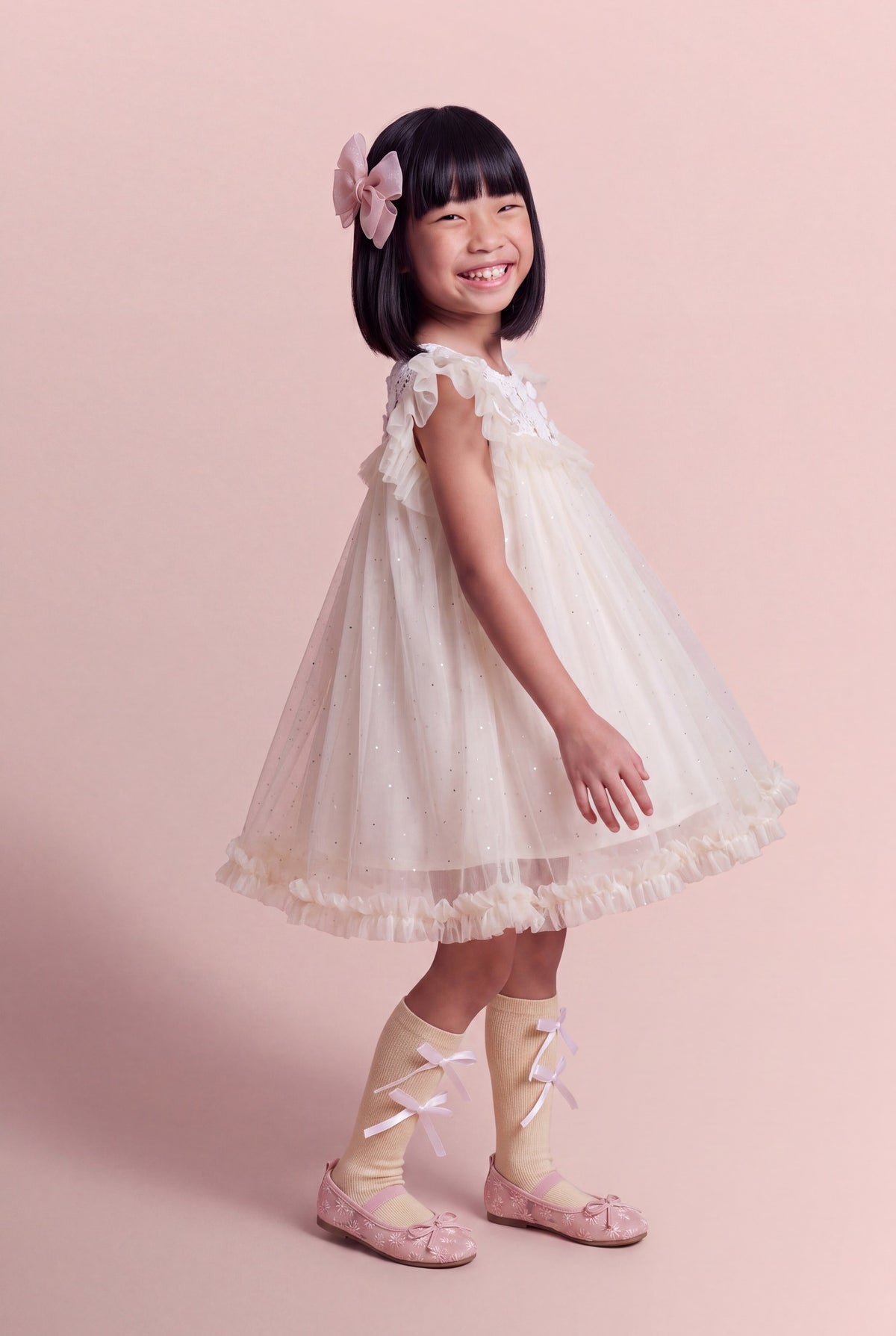 Three quarter view of the Primrose ivory flower girl dress showing the depth of the tulle skirt